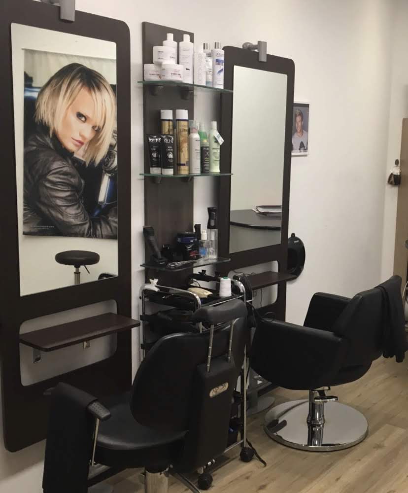Een werkplek in de salon: kappersstoel, spiegel en een rek met haarproducten